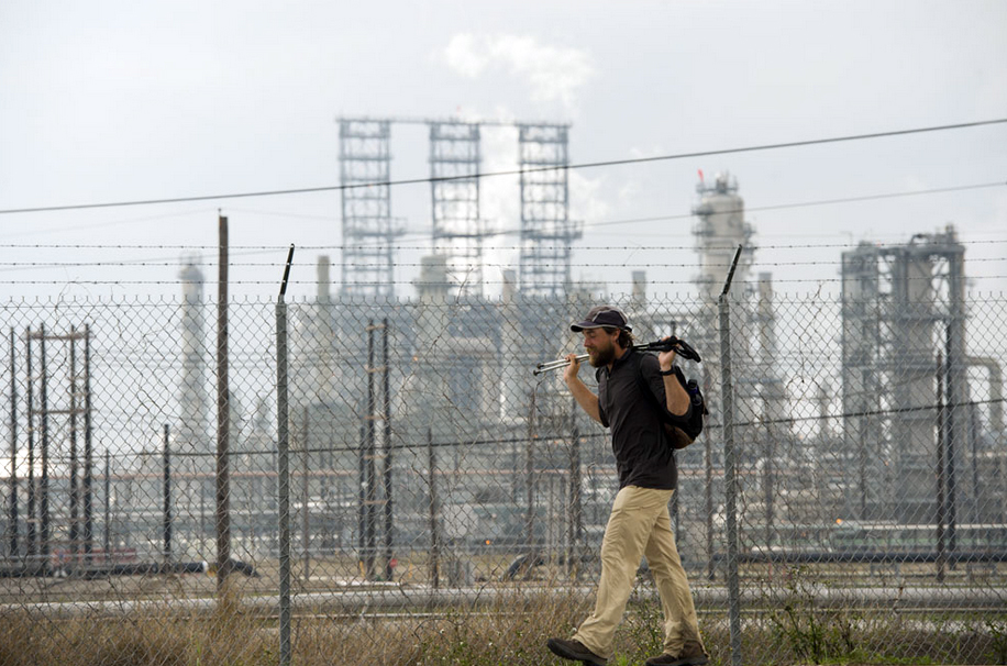 Ken Ilgunas passes a Texas oil refinery on the final leg of his walk along the length of the proposed Keystone XL Pipeline project. Photo by Woody Welch