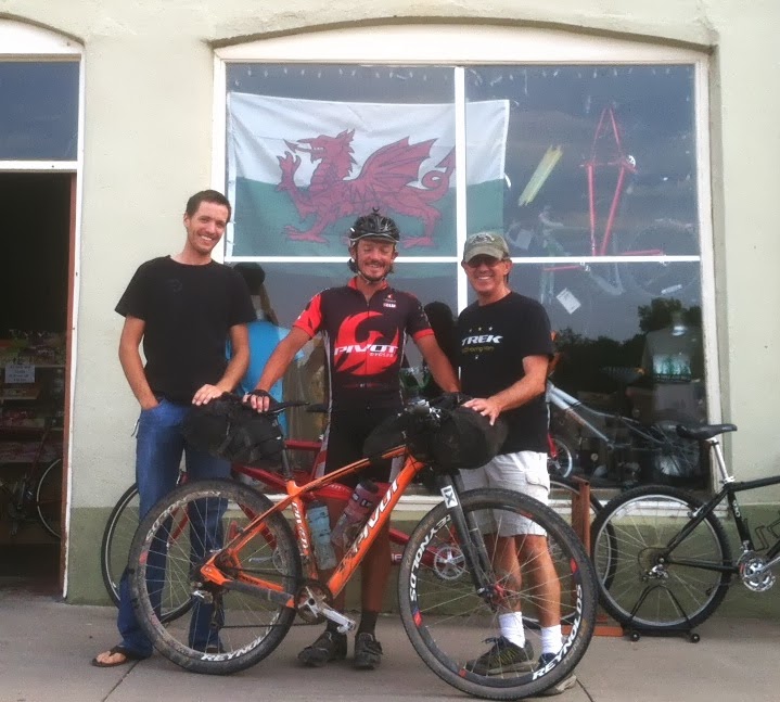 Jack Brennan, race director of Tour of the Gila and proprietor of Gila Hike & Bike in Silver City, ordered a Welsh flag to fly at the shop in honor of Mike Hall, center. Photo via Matt Lee. 